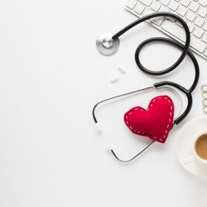 stethoscope-with-red-heart-near-medicines-cup-coffee-keyboard-white-desk_23-2148213961